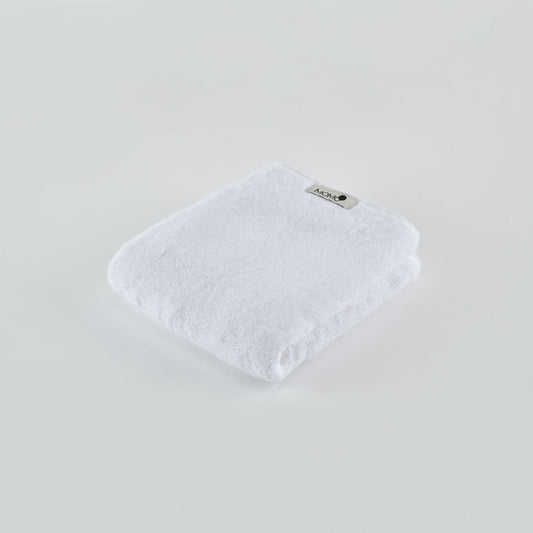 White bamboo towel by Momo Cotton folded on light background with brand label visible