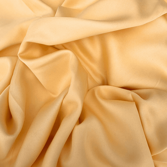 Capa de edredão em bambu cor champanhe mostrando textura macia, luxuosa e detalhe de drapeado.