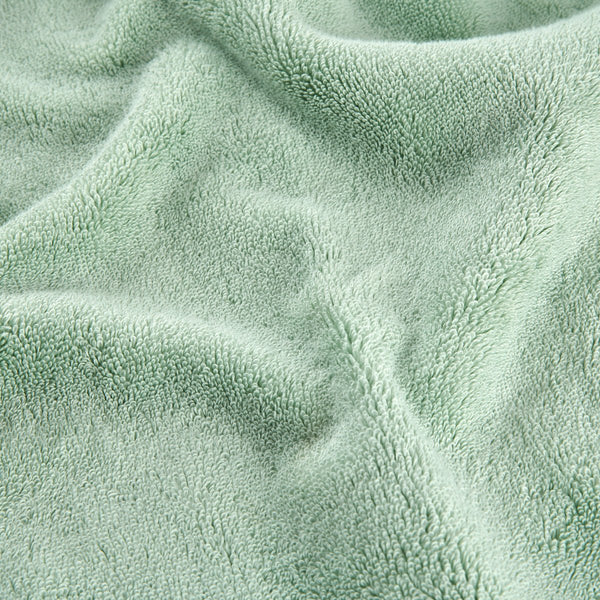 Green bamboo towel set showing soft textured fabric surface detail in close-up view