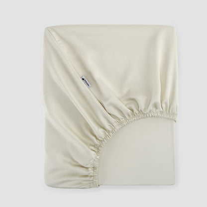 Lençol de baixo ajustável branco pérola bambu by Momo Cotton – tecido de cetim 300 fios, suave, respirável e sustentável.